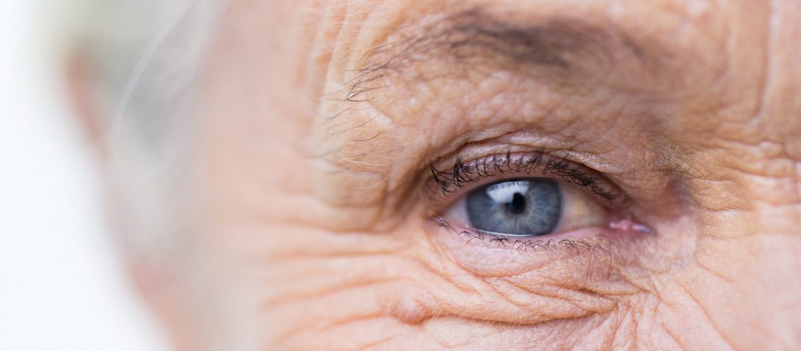 age, vision and old people concept - close up of senior woman face and eye